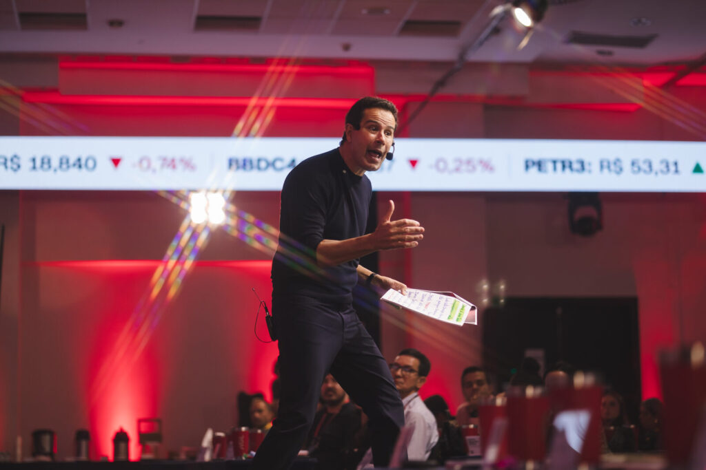 Palestrante na passarela do palco próximo ao público, com painel de LED ao fundo, no evento corporativo RGV 40 em São Paulo