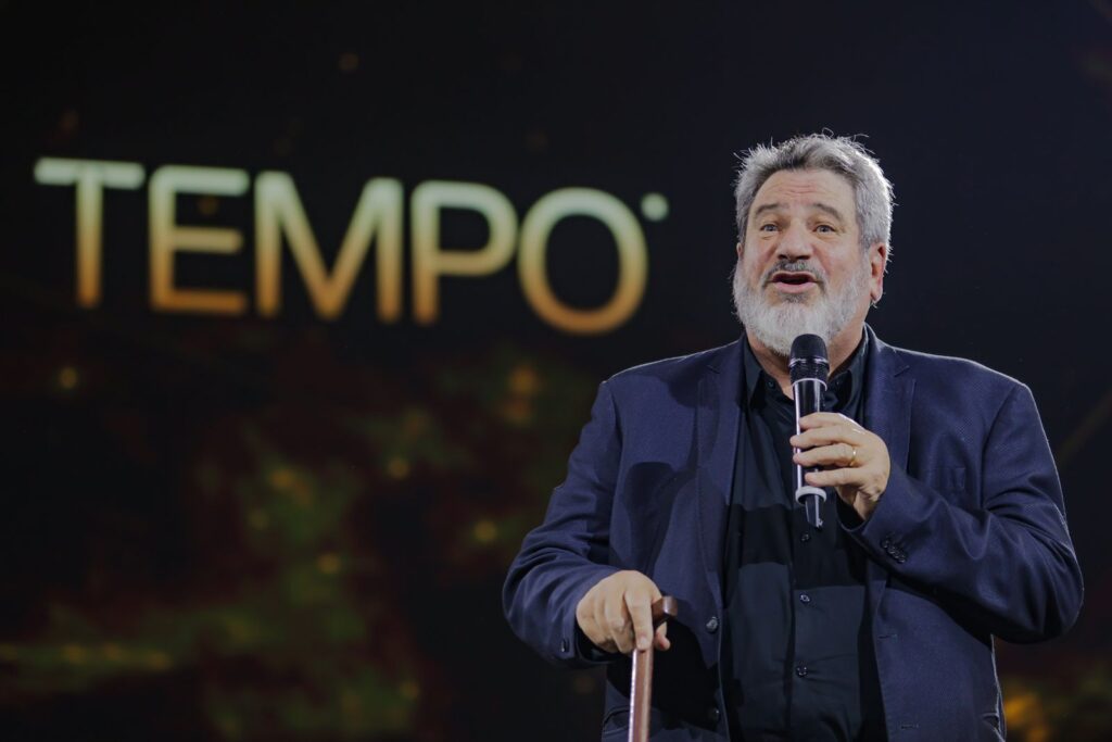 Mario Sergio Cortella palestrando em O Preço do Tempo, com a palavra TEMPO no painel de LED ao fundo