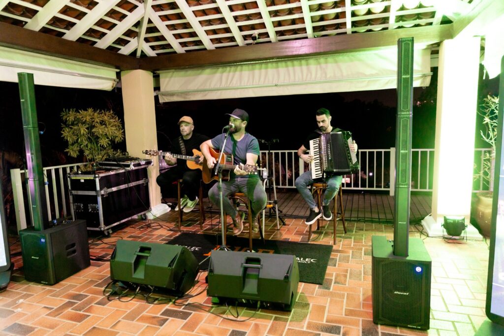 Banda na área externa com caixas de som e monitores de retorno.