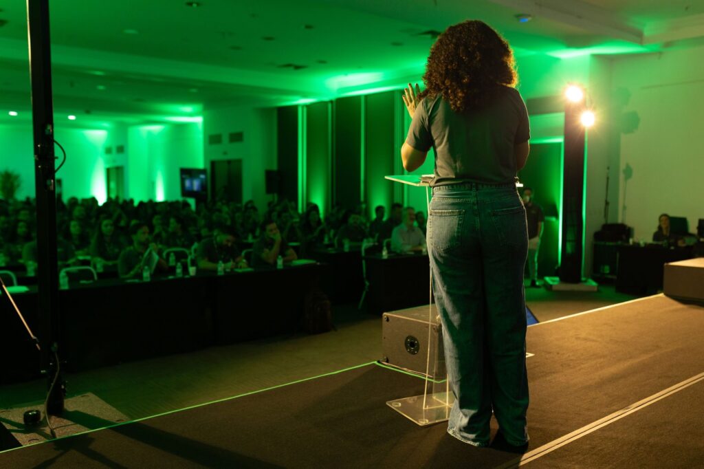 Vista do palco para a plateia e a iluminação verde do ambiente.
